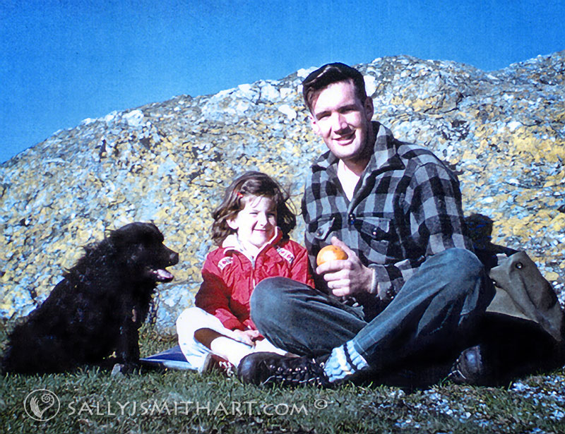 A small girl and her father on top of a mountain